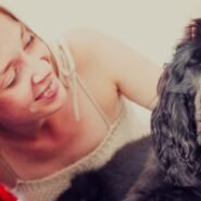 Femme souriante caressant un chien noir