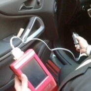 Technicien effectuant un diagnostic auto avec un outil électronique