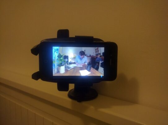 Smartphone filmant une personne travaillant à un bureau