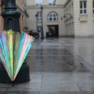 Parapluie aux reflets irisés posé contre un lampadaire