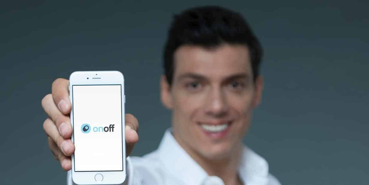Homme montrant un smartphone avec l'application OnOff affichée à l'écran