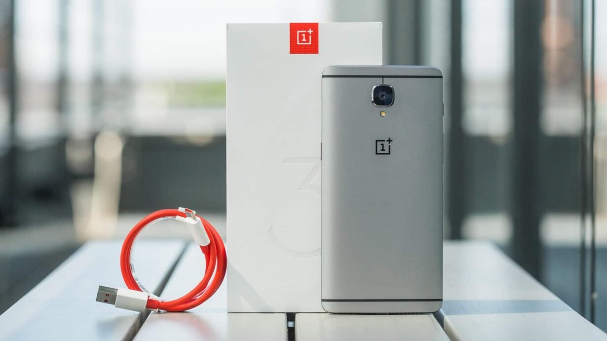 Smartphone gris avec câble USB rouge et boîte blanche