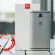 Smartphone gris avec câble USB rouge et boîte blanche