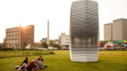 Groupe de personnes près d'une tour moderne dans un parc ensoleillé