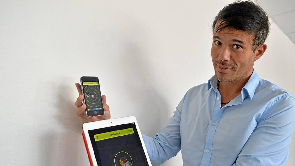 Homme présentant une application sur smartphone et tablette