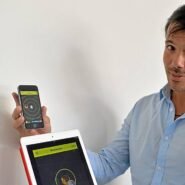 Homme présentant une application sur smartphone et tablette