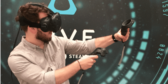 Homme utilisant un casque de réalité virtuelle et des contrôleurs