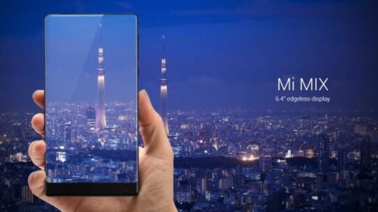 Main tenant un Mi MIX devant un panorama nocturne de Tokyo