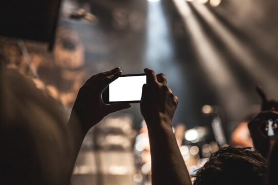 Personne prenant une photo avec un smartphone lors d'un concert