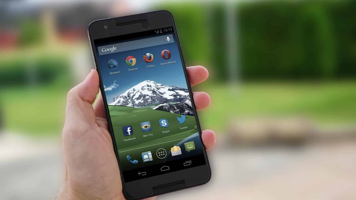 Main tenant un smartphone avec des applications sur l'écran