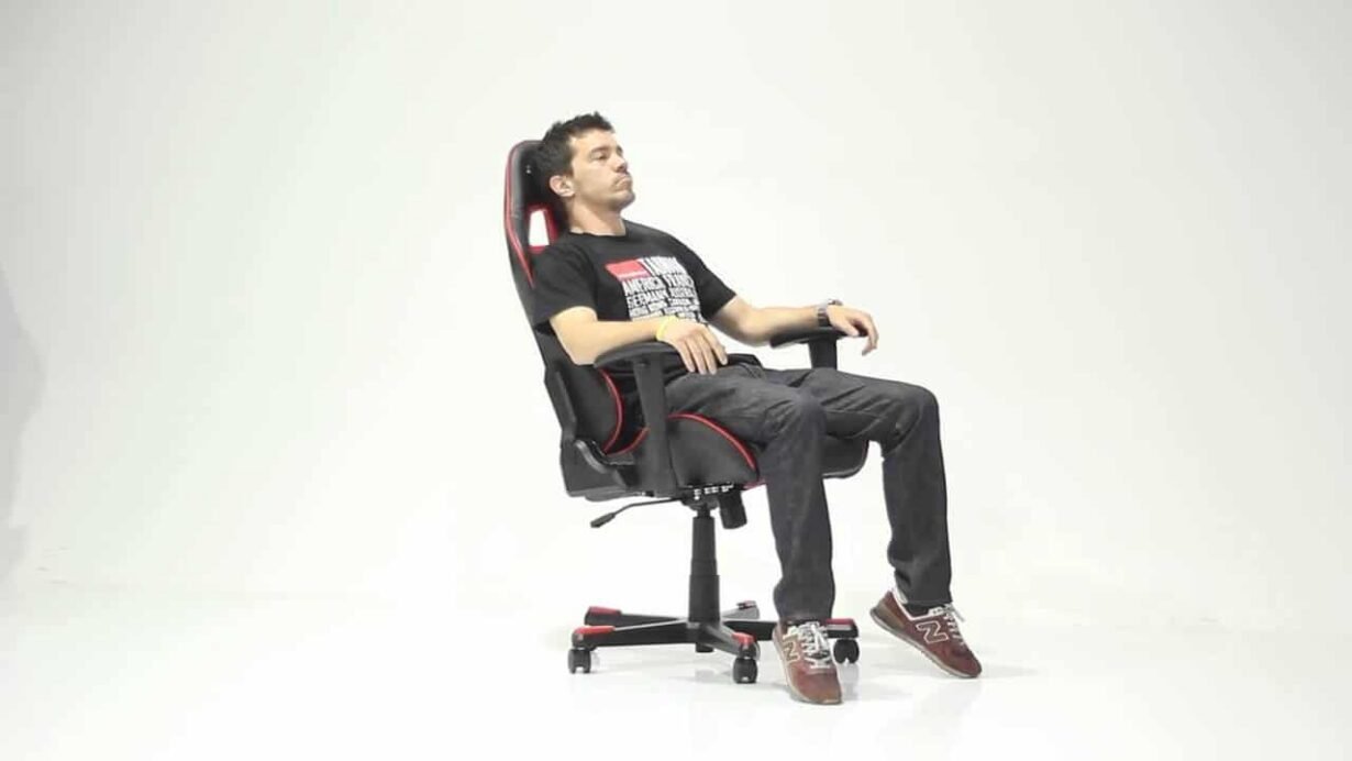 Homme assis dans un fauteuil de gamer noir et rouge
