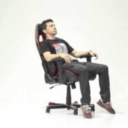 Homme assis dans un fauteuil de gamer noir et rouge