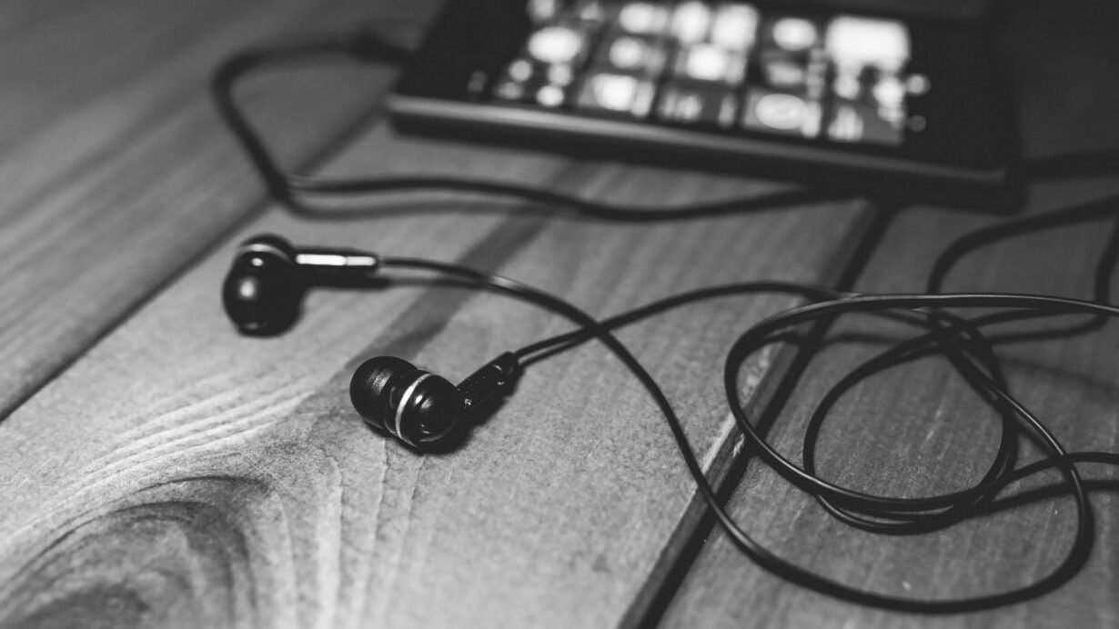 Écouteurs noirs et smartphone sur une table en bois