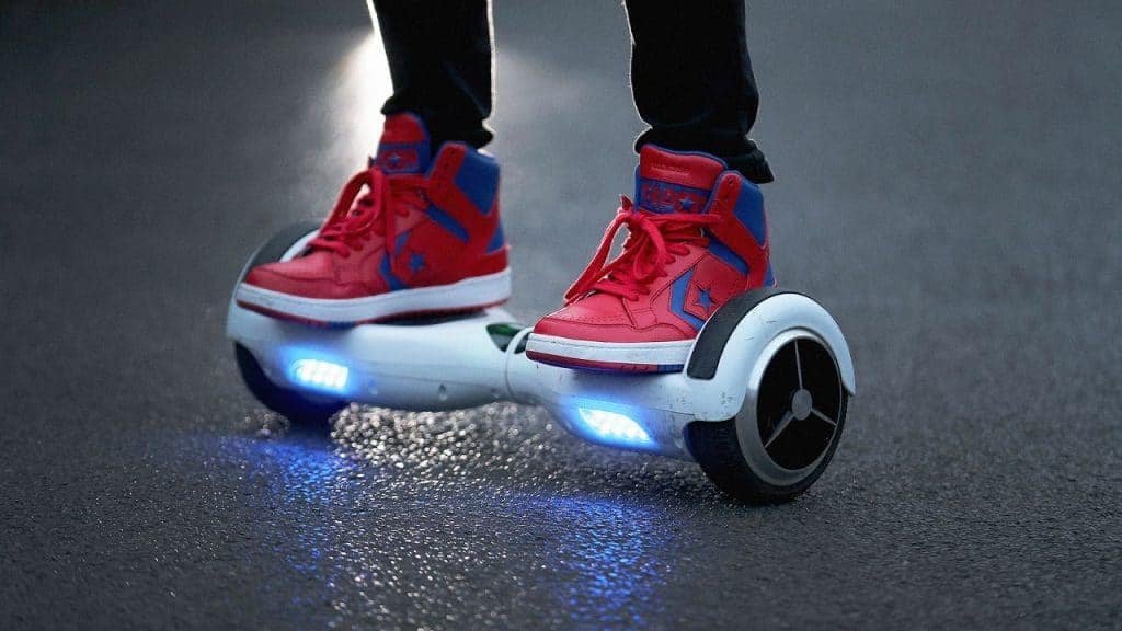 Personne en chaussures rouges sur un hoverboard éclairé