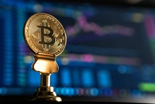 Pièce de bitcoin devant des graphiques numériques flous