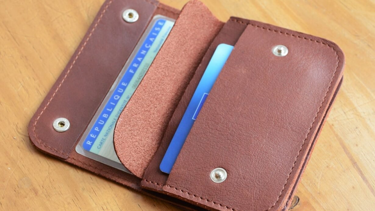 Portefeuille en cuir marron ouvert avec des cartes à l'intérieur