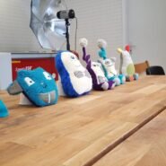 Peluches colorées alignées sur une table en bois dans un studio