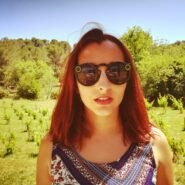 Femme portant des lunettes connectées devant un vignoble ensoleillé