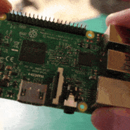 Gros plan sur un micro-ordinateur Raspberry Pi tenu par des mains
