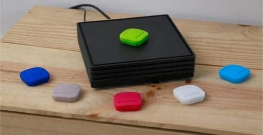 Boutons colorés sur une base noire posée sur une table en bois