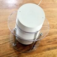 Enceinte cylindrique blanche sur une table en bois