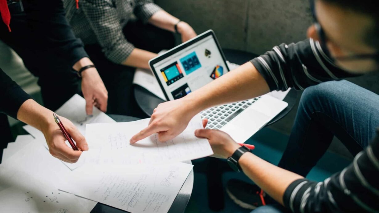 Groupe de personnes travaillant autour d'un ordinateur portable