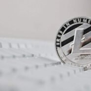 Pièce de Litecoin posée sur un clavier d'ordinateur blanc
