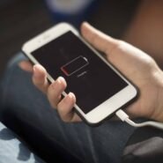 Main tenant un téléphone en charge avec batterie faible