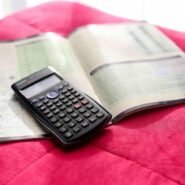 Calculatrice noire posée sur un manuel ouvert