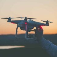 Main tenant un drone au coucher du soleil
