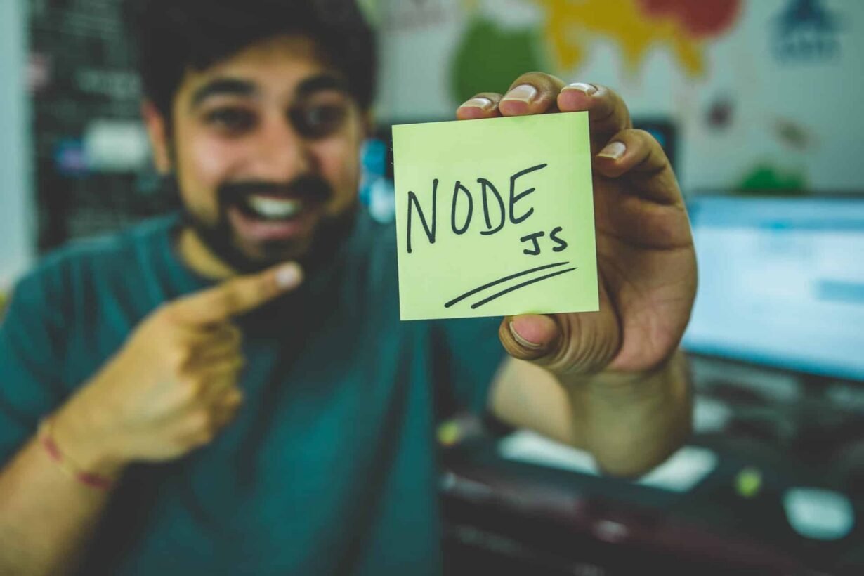Homme montrant un post-it avec Node.js écrit dessus