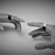 Deux mains tendues avec des anneaux technologiques au bout des doigts