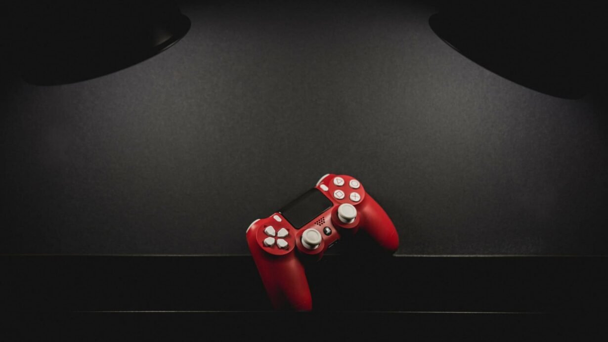 Manette de jeu rouge posée sur une surface noire
