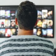 Homme de dos regardant un écran de télévision