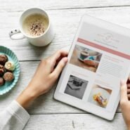 Personne lisant une tablette avec café et chocolats sur table