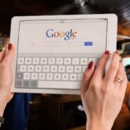 Personne utilisant une tablette pour rechercher sur Google dans un café
