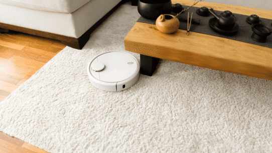 Aspirateur robot blanc sur un tapis dans un salon moderne