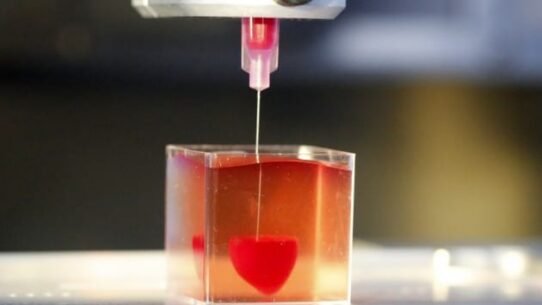 Imprimante 3D créant un cœur rouge dans un gel transparent