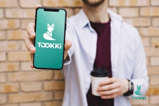 Homme montrant un smartphone avec l'application Tookki