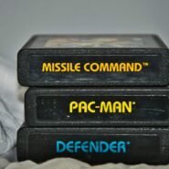 Trois cartouches de jeux rétro empilées : Missile Command, Pac-Man, Defender