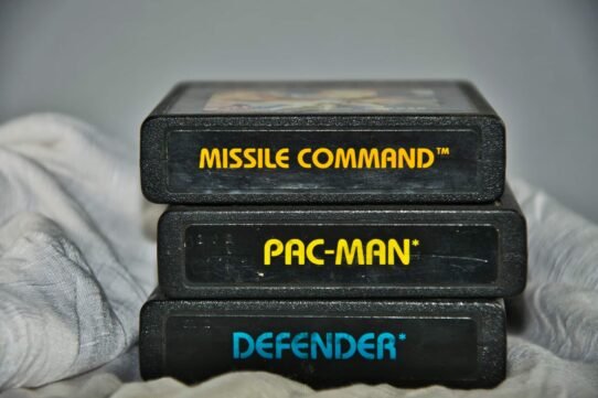 Trois cartouches de jeux rétro empilées : Missile Command, Pac-Man, Defender