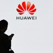 Silhouette d'une femme avec smartphone devant le logo Huawei