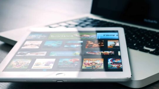 Tablette affichant des applications de streaming devant un ordinateur portable