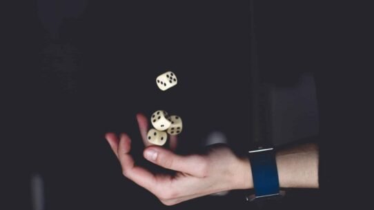 Main jonglant avec quatre dés en lévitation