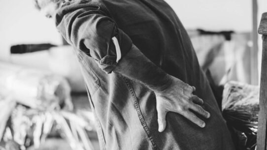 Homme se tenant le bas du dos, exprimant une douleur lombaire