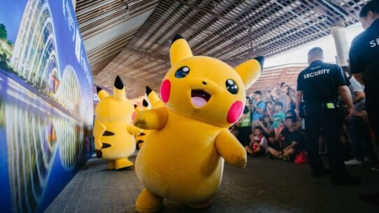 Mascotte Pikachu souriante devant une foule lors d'un événement