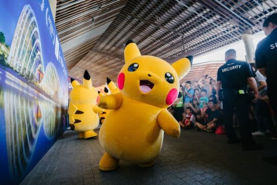 Mascotte Pikachu souriante devant une foule lors d'un événement