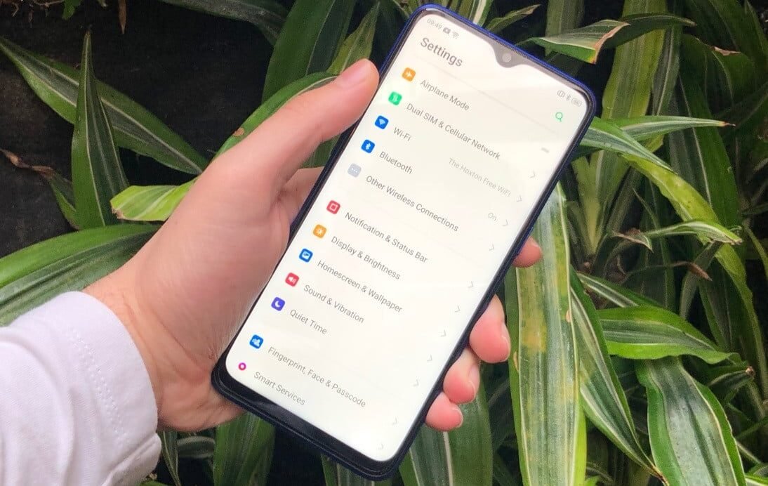 Main tenant un smartphone affichant les réglages
