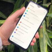 Main tenant un smartphone affichant les réglages