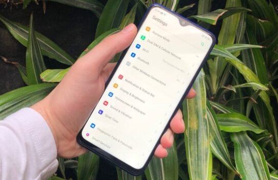 Main tenant un smartphone affichant les réglages